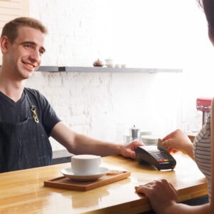A cashier gives a client a POD credit card reader.